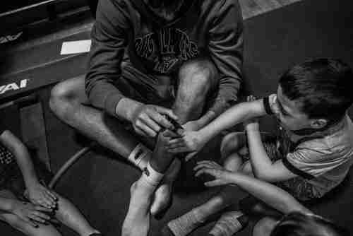 A black and white image of a grand valley student playing with a preschool student. 